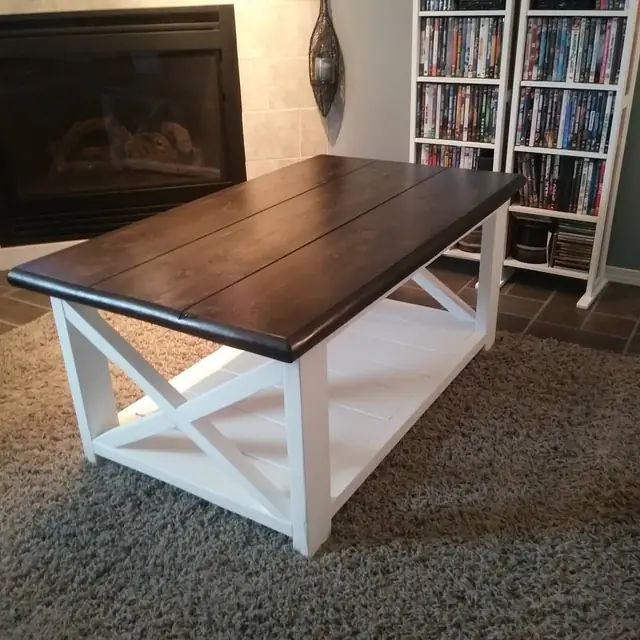 Dark-topped rustic coffee table with white X base in a living room
