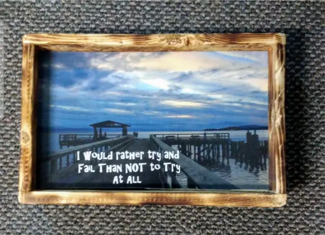 Decoupage sign of a pier at sunset with an inspirational quote in a torched frame
