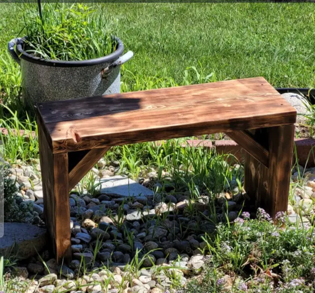 Stained rustic garden bench with angled supports