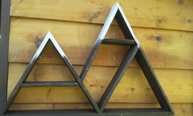 Black mountain-shaped wall shelves in rustic wood