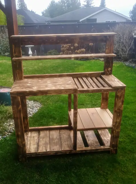 Torched wood potting bench with upper shelf and slatted work surface