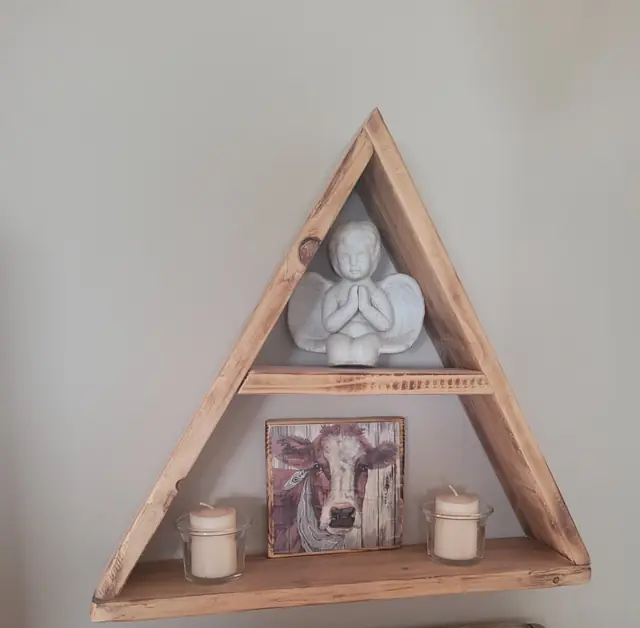 Rustic triangle wall shelf displaying candles and decor